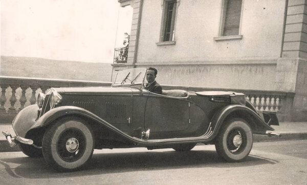 Vintage image, 1934 with car and driver on a promenade