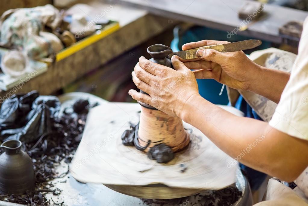 Hands working on pottery wheel