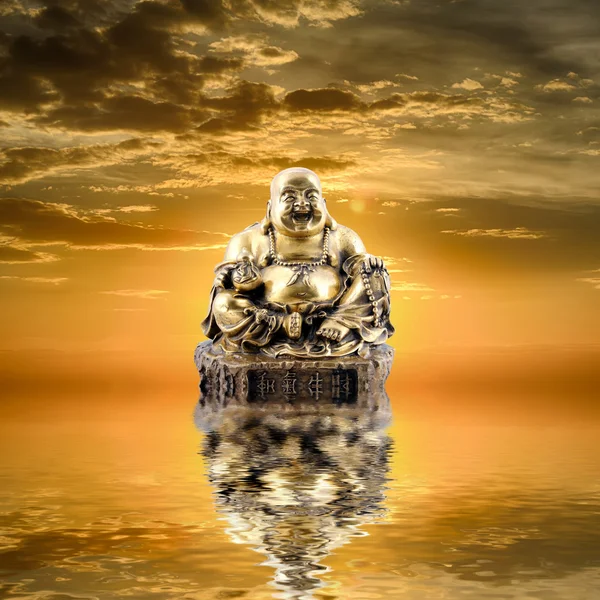 Feng Shui background. Laughing Buddha or Budai is reflected in water at sunrise