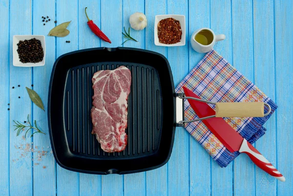 Rått kött i en stekpanna och kryddor för grillen — Stockfoto