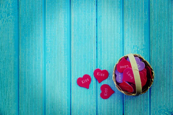 Panier complet avec des cœurs sur un fond en bois bleu. Photo en style vintage — Photo