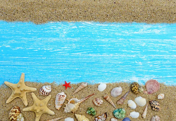 Sand, seashells and starfish on a blue wooden background — Stock Photo, Image