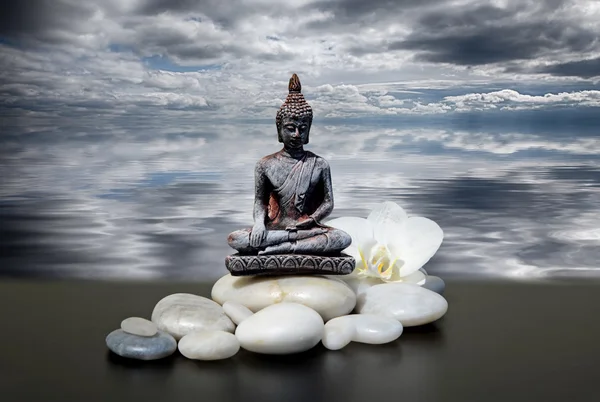 Zen lub Feng-Shui tła Buddą, zen stone, białe kwiaty orchidei i ciemne niebo i chmury odbicie w wodzie — Zdjęcie stockowe