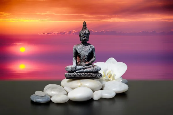 Zen ou Feng-Shui fundo-Buda, pedra zen, flores brancas da orquídea.No fundo nascer do sol sobre o mar — Fotografia de Stock