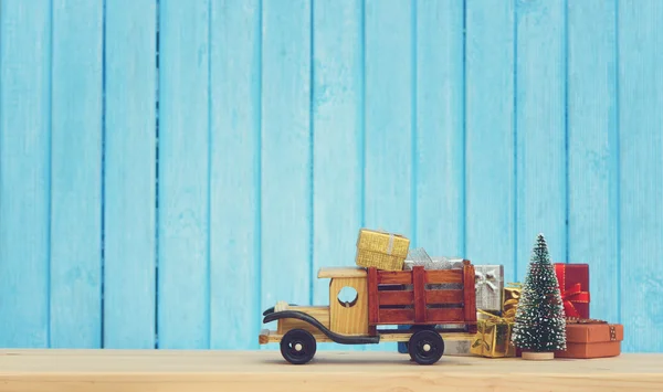 Christmas background.Toy truck carries gifts and a Christmas tree. Photo in vintage style — Stock Photo, Image