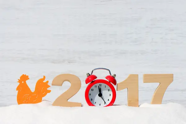 Gallo, símbolo de 2017 en el calendario chino. Gallo y los números 2017 en una deriva de nieve sobre un fondo de madera — Foto de Stock