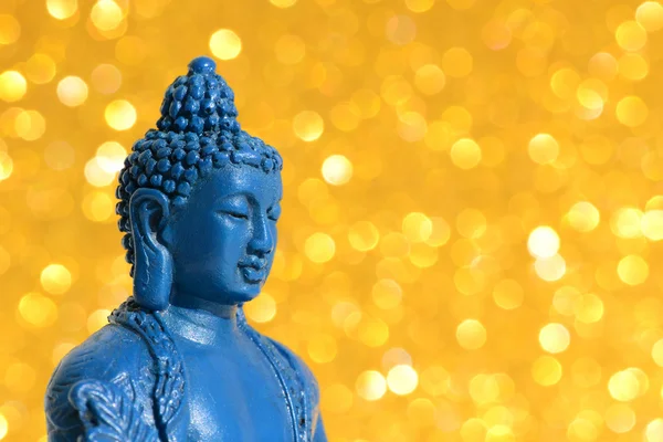 Голова Будды крупным планом на ярком золотом блестящем фоне с боке — стоковое фото