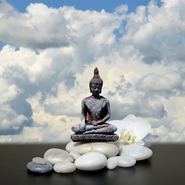 Buda, zen stone, beyaz orkide çiçekleri ve gökyüzü arka plan — Stok fotoğraf