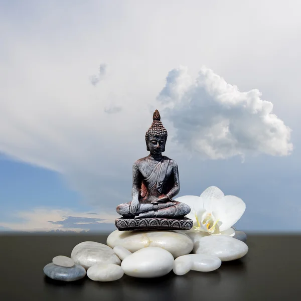 Buddha, piedra zen, flores blancas de la orquídea y fondo del cielo —  Fotos de Stock