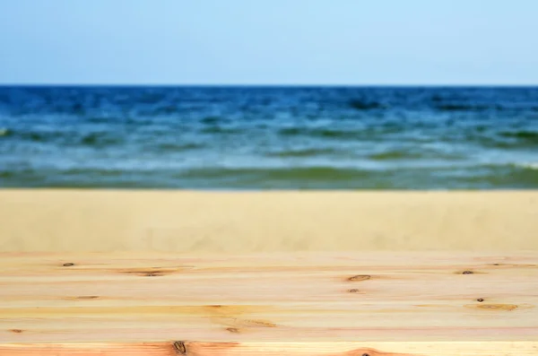 Prázdný dřevěný stůl se používá k zobrazení nebo k fotomontáž vašich výrobků. Na pozadí rozmazané moře a nebe — Stock fotografie