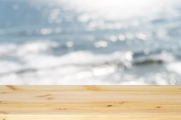 Tablero de madera vacío utilizado para mostrar o montar sus productos. En el fondo mar borroso — Foto de Stock