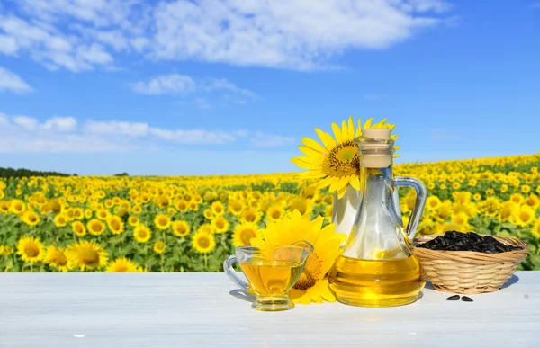 Sunflowers, seeds and sunflower oil. In the background a field of sunflowers — Stock Photo, Image