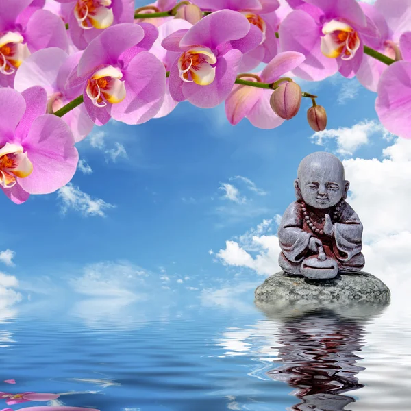 Buda, pedra zen e flores de orquídeas refletidas na água — Fotografia de Stock
