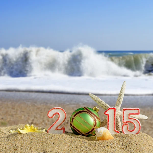 Ano Novo 2015 assina com conchas, estrela do mar e bola de Natal em uma areia de praia — Fotografia de Stock