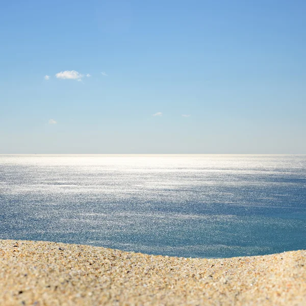 Un mucchio di sabbia su una spiaggia contro il mare e il cielo. Montaggio pronto per l'esposizione del prodotto — Foto Stock
