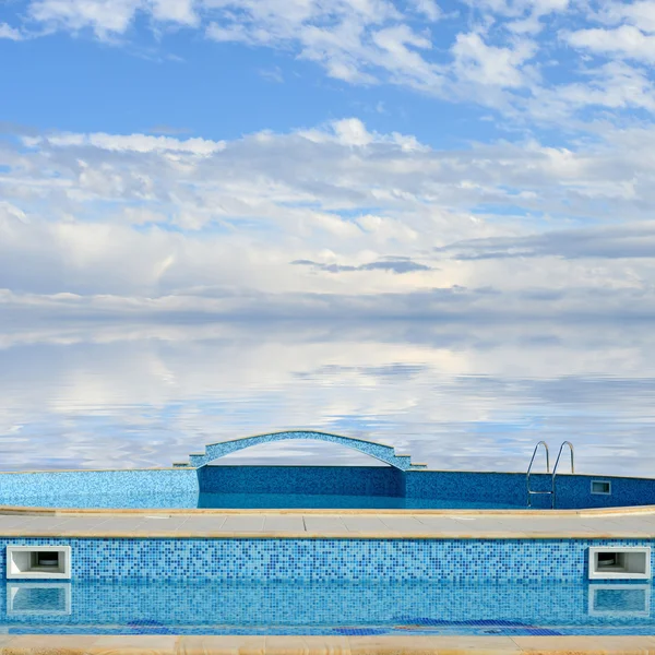 Outdoor swimming pool on a background of sky and sea — Stock Photo, Image