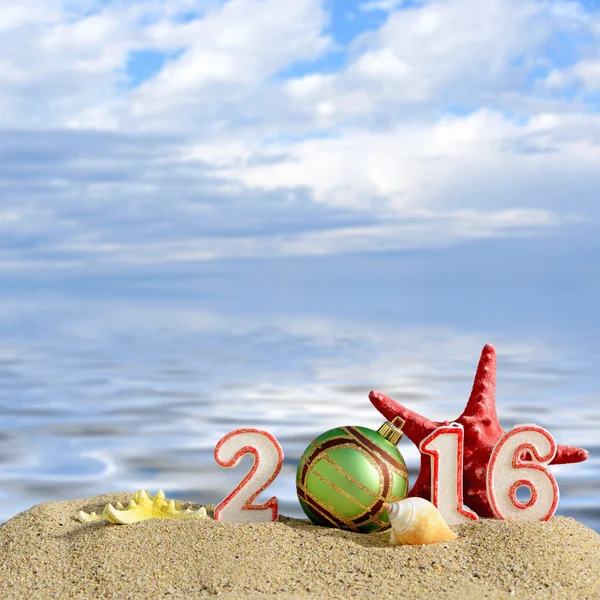 Lo sfondo di Natale con Anno nuovo il 2016 firma su una sabbia di spiaggia — Foto Stock