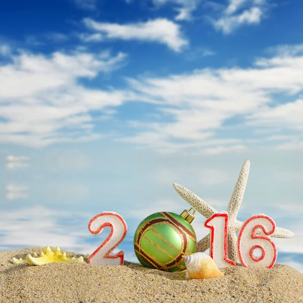Noel arka plan ile yeni yıl 2016 imzalamak bir sahil kumu — Stok fotoğraf
