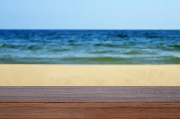 Empty wooden desk, blurred sea and blue sky — Stock fotografie