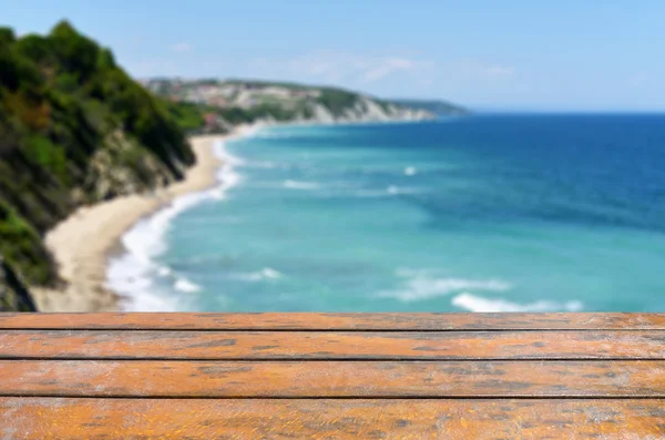 Empty wooden desk, blurred sea and blue sky — Stock Photo, Image