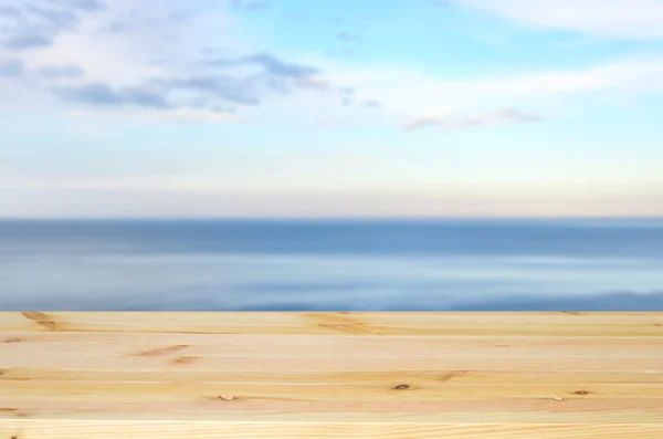 Escritorio de madera vacío, mar borroso y cielo azul — Foto de Stock