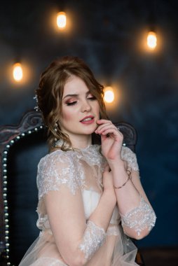 Beyaz iç çamaşırlı, güzel, seksi esmer kız stüdyoda poz veriyor.