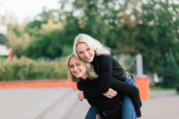 Duas Jovens Mulheres Andando Sorrindo Abraçando Beijando Livre — Fotografia de Stock