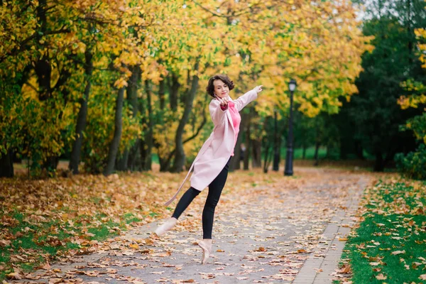 Balerina Tańczy Naturze Wśród Jesiennych Liści Jasnym Płaszczu — Zdjęcie stockowe