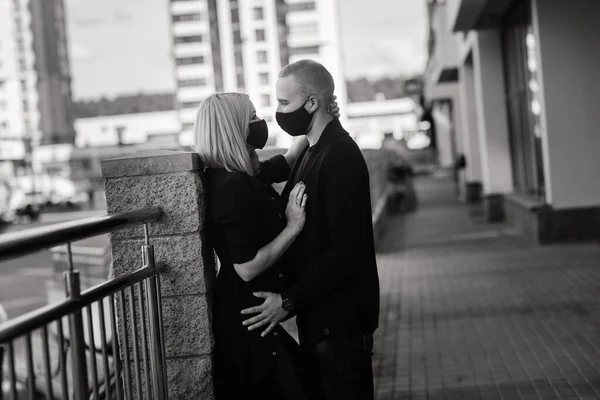 流行のファッショナブルな保護マスクを身に着けているカップル デニムジャケット コロナウイルス感染の隔離中にヨーロッパの街の空の通りを歩く — ストック写真