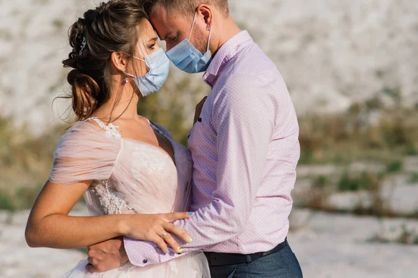 Düğün günlerinde karantina sırasında parkta maske takan genç bir çift..