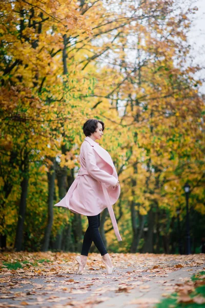 Balerina Tańczy Naturze Wśród Jesiennych Liści Jasnym Płaszczu — Zdjęcie stockowe
