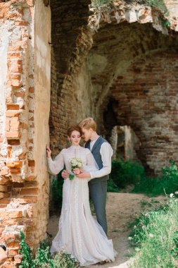 Çok hoş kızıl saçlı genç evli mutlu bir çift gün batımında dışarıda öpüşüyor.