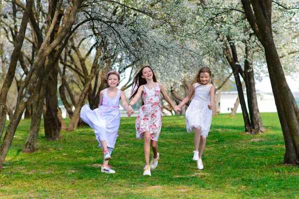 Drie Schattige Meisjes Jurken Houden Elkaars Hand Vast Lente Tuin — Stockfoto