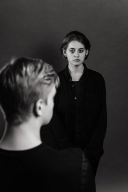 Stüdyoda saldırgan bir adamla umutsuz bir kadın, aile içi şiddet kavramı