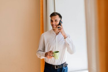 Rahatlamış genç adam işten dinleniyor. Adam ofis işyerinde mola vermeyi seviyor.