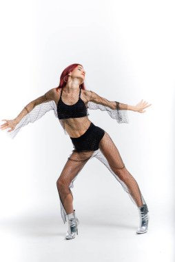 Seksi direk kızıl dansçısı vücudunu gösteriyor.