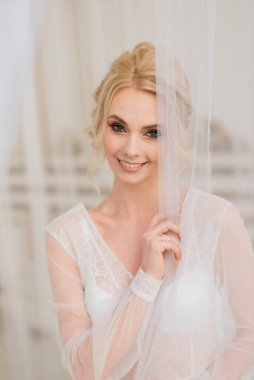 Yatak odası elbisesi içinde güzel bir gelinin sabahı. Stüdyo, iç mekan.