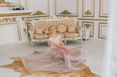 Yatak odası elbisesi içinde güzel bir gelinin sabahı. Stüdyo, iç mekan.