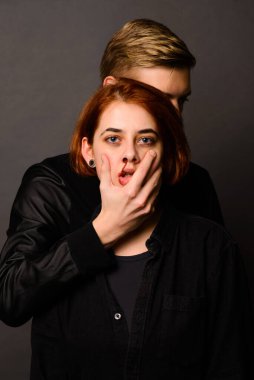 Stüdyoda saldırgan bir adamla umutsuz bir kadın, aile içi şiddet kavramı