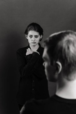 Stüdyoda saldırgan bir adamla umutsuz bir kadın, aile içi şiddet kavramı