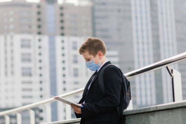 Öğrenci okuldan koruyucu maske takarak çıkıyor.