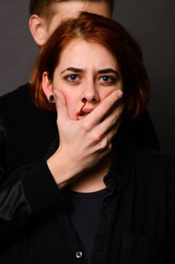 Stüdyoda saldırgan bir adamla umutsuz bir kadın, aile içi şiddet kavramı