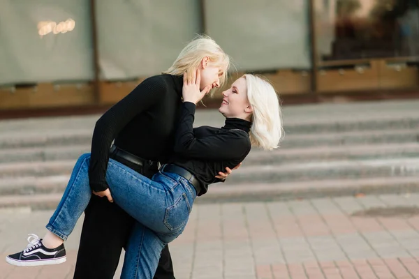 两名年轻的女性走在户外拥抱亲吻 — 图库照片