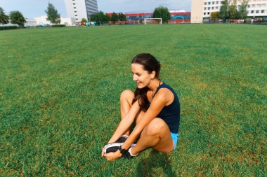 Sporcu atletizm pistinde koşuyor ve kardiyo çalışıyor. Kadınlar yaz stadyumunda yarışmak için koşuyorlar..