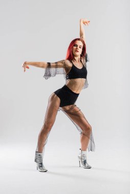 Seksi direk kızıl saçlı dansçı güzel vücudunu gösteriyor.