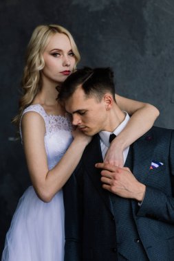 Klasik bir stüdyonun içinde şirin bir düğün çifti. Öpüşüyorlar ve sarılıyorlar..