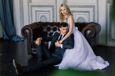 Klasik bir stüdyonun içinde şirin bir düğün çifti. Öpüşüyorlar ve sarılıyorlar..