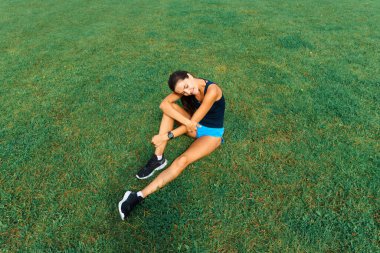 Sporcu atletizm pistinde koşuyor ve kardiyo çalışıyor. Kadınlar yaz stadyumunda yarışmak için koşuyorlar..