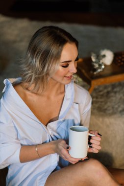 Yeni yılı ve Noel 'i kutlamak için köknar ağacının yanındaki sarışın kadın..