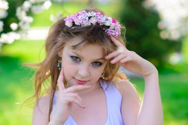 Güzel bir bahar gününde, çiçek açan elma bahçesinde güzel bir kız.